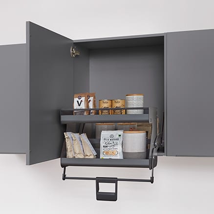 Meuble haut gris ouvert, panier abaissé devant le meuble et chargé de paquets et de bocaux