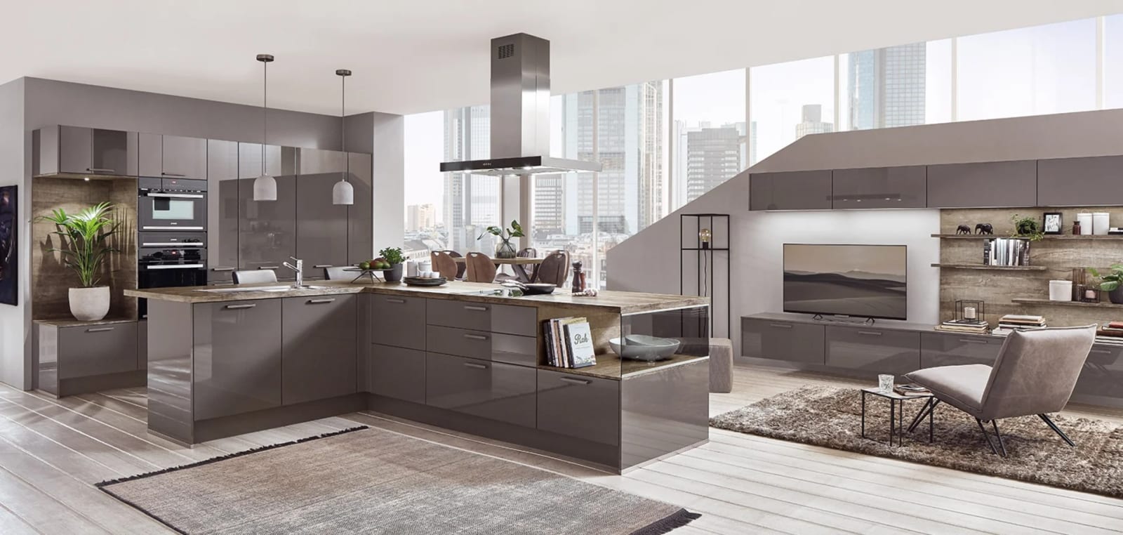 Cuisine en L à façades brillantes gris taupe, îlot, hotte suspendue en inox et grande baie vitrée sur la ville