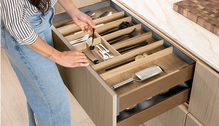 Bois véritable en cuisine : range-couverts massif dans un tiroir ouvert, veinage et nœuds apparents