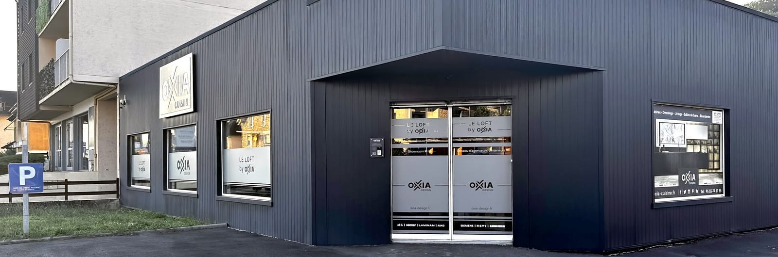 Façade du showroom OXIA à Brive, avenue Ribot : bardage gris anthracite, enseigne et grandes vitrines